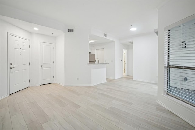 unfurnished living room with recessed lighting, light wood-type flooring, visible vents, and baseboards