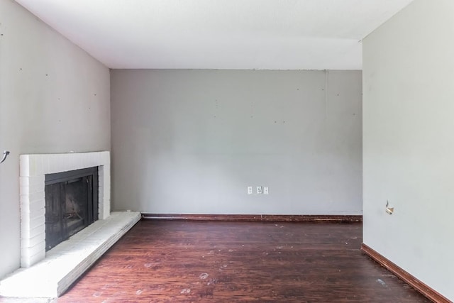 unfurnished living room featuring a fireplace and dark hardwood / wood-style flooring