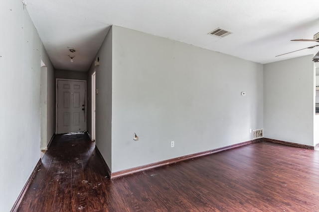 empty room featuring dark wood-type flooring and ceiling fan