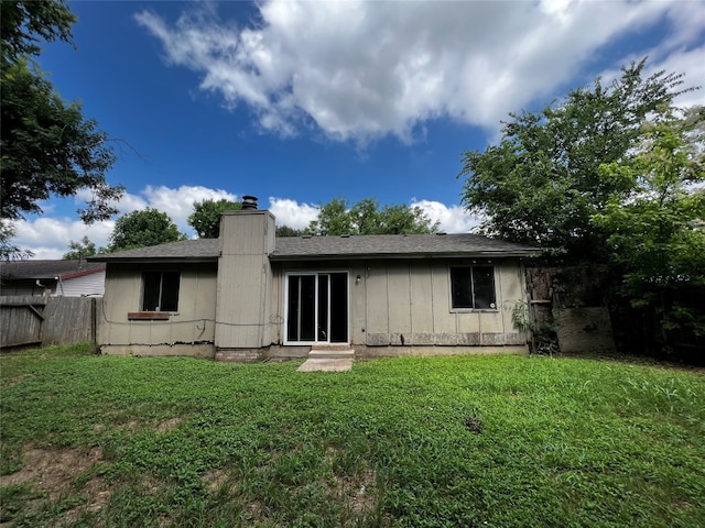 rear view of property featuring a yard