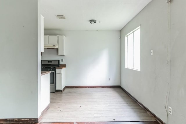 kitchen with white cabinetry, stainless steel gas range oven, and light wood-type flooring