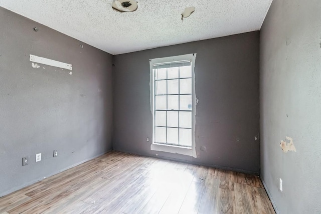 empty room featuring light hardwood / wood-style floors and a textured ceiling