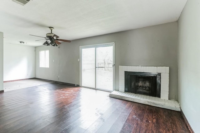 unfurnished living room with a fireplace, a wealth of natural light, hardwood / wood-style floors, and ceiling fan