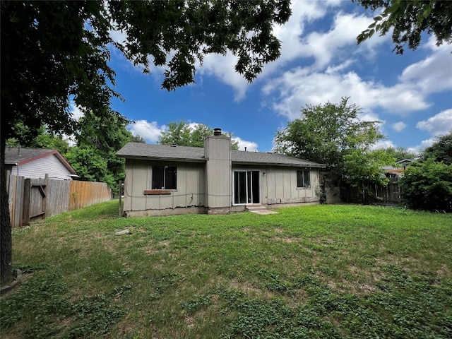 rear view of property featuring a lawn