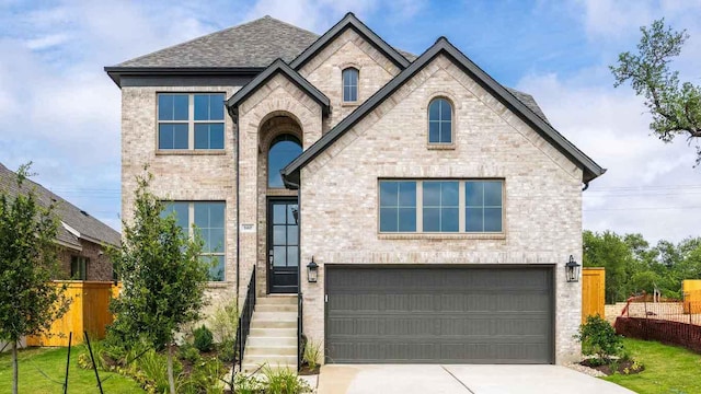 140 Spring Bluff Ln, Georgetown, TX 78628 - view of front of home with an attached garage, concrete driveway, brick siding, and a shingled roof