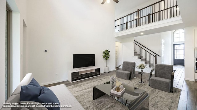140 Spring Bluff Ln, Georgetown, TX 78628 - living area featuring stairway, a towering ceiling, wood finished floors, and a ceiling fan