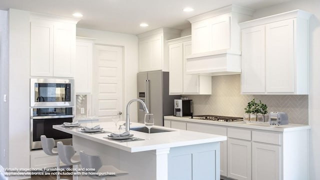 140 Spring Bluff Ln, Georgetown, TX 78628 - kitchen with stainless steel appliances, decorative backsplash, white cabinets, a kitchen island with sink, and premium range hood