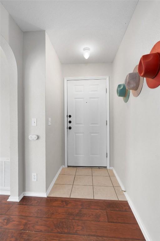 doorway to outside with light tile patterned flooring