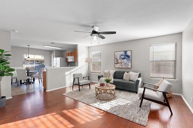 living room with dark hardwood / wood-style flooring and ceiling fan