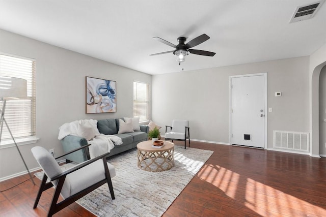 living room with ceiling fan and dark hardwood / wood-style flooring