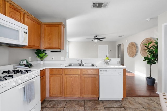 kitchen featuring sink, light tile patterned floors, ceiling fan, kitchen peninsula, and white appliances