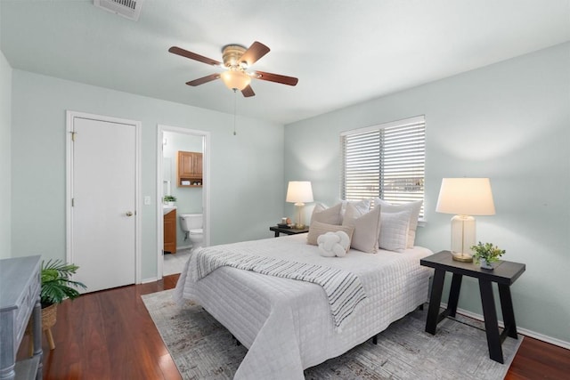 bedroom with ceiling fan, connected bathroom, and dark hardwood / wood-style flooring