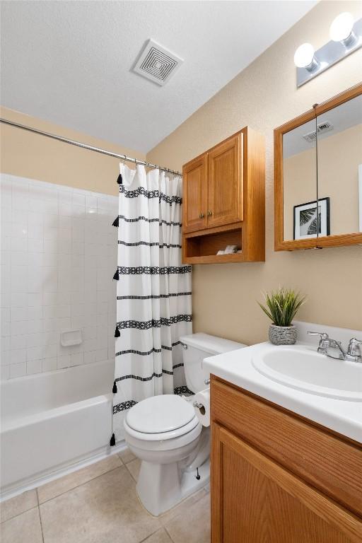 full bathroom featuring vanity, shower / bathtub combination with curtain, tile patterned floors, and toilet