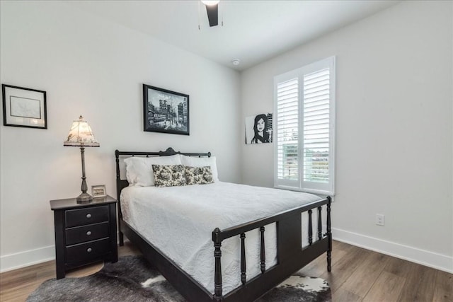 bedroom with dark hardwood / wood-style flooring and ceiling fan