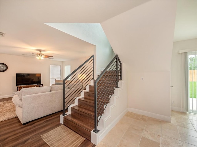 staircase featuring wood-type flooring, lofted ceiling, and ceiling fan