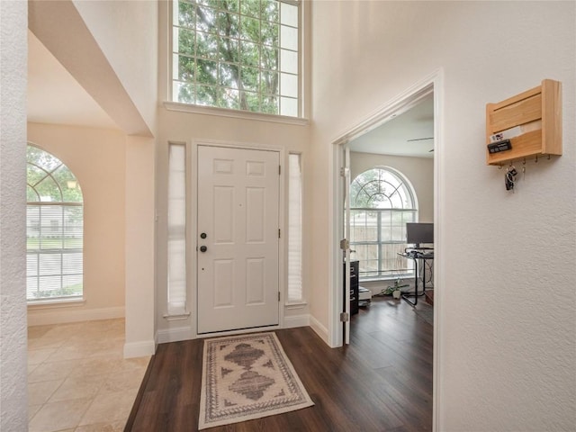 entryway featuring hardwood / wood-style flooring and a towering ceiling