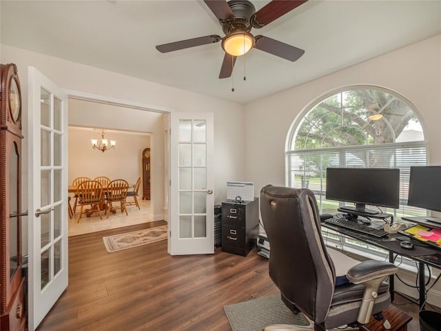 office space featuring dark hardwood / wood-style flooring, ceiling fan with notable chandelier, and french doors