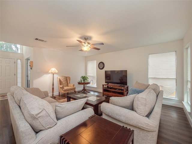 living room featuring dark wood-type flooring and ceiling fan