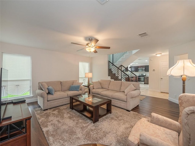 living room featuring ceiling fan, hardwood / wood-style floors, and a wealth of natural light