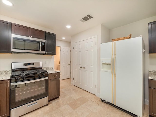 kitchen featuring light stone counters, dark brown cabinetry, and appliances with stainless steel finishes