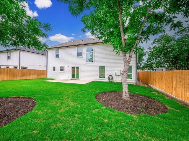 rear view of house featuring a lawn and a patio area