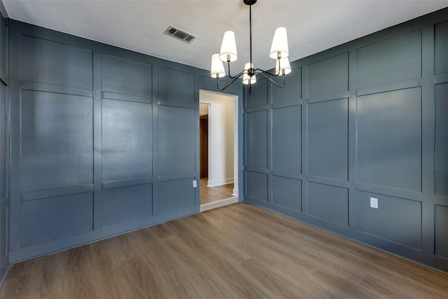 unfurnished bedroom featuring a chandelier and light hardwood / wood-style floors