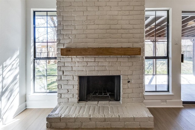 details with a brick fireplace and wood-type flooring