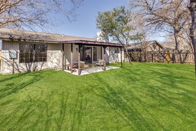 back of house featuring a lawn and a patio area