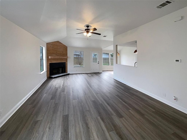 unfurnished living room with ceiling fan, a large fireplace, lofted ceiling, and dark hardwood / wood-style floors