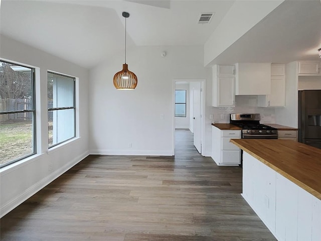 kitchen with white cabinetry, pendant lighting, wood counters, and gas range