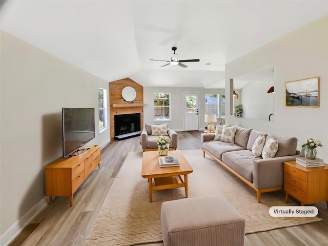 1406 Rio Bravo Loop, Leander, TX 78641 - living area with light wood-style flooring, vaulted ceiling, a ceiling fan, and a fireplace