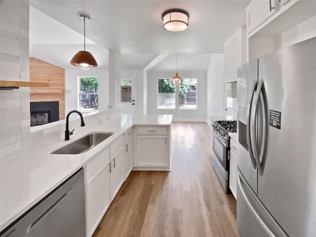 1406 Rio Bravo Loop, Leander, TX 78641 - kitchen with appliances with stainless steel finishes, light wood finished floors, plenty of natural light, light countertops, and vaulted ceiling
