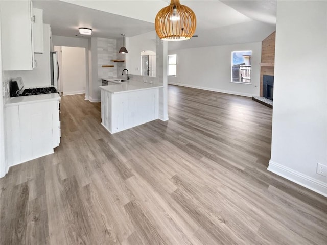 1406 Rio Bravo Loop, Leander, TX 78641 - kitchen with a fireplace, white cabinets, light countertops, open floor plan, and range with gas cooktop