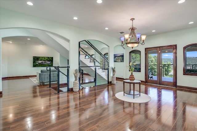 foyer with french doors, dark hardwood / wood-style flooring, and a notable chandelier