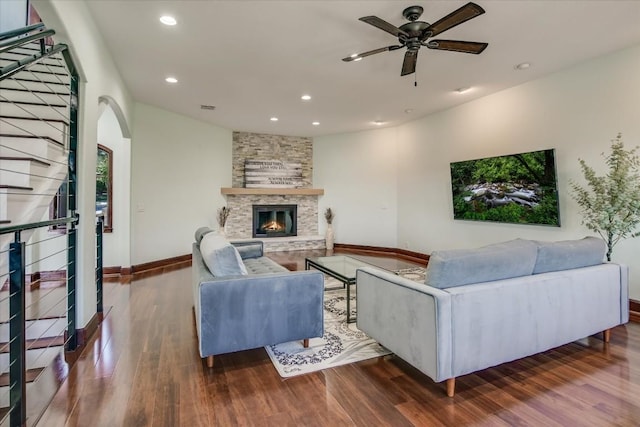 living room with hardwood / wood-style flooring, ceiling fan, and a fireplace