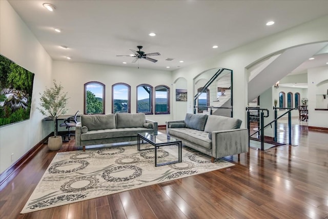 living room with dark wood-type flooring and ceiling fan