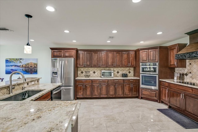 kitchen with sink, hanging light fixtures, stainless steel appliances, light stone countertops, and backsplash