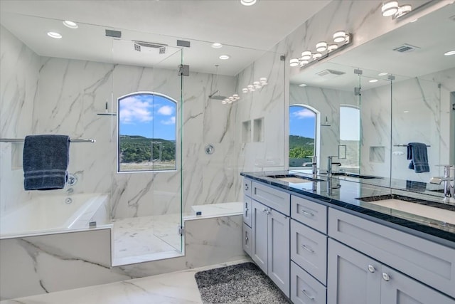 bathroom featuring vanity and independent shower and bath