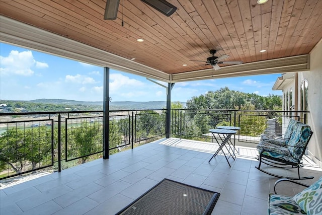 view of patio / terrace with ceiling fan, a balcony, and a mountain view