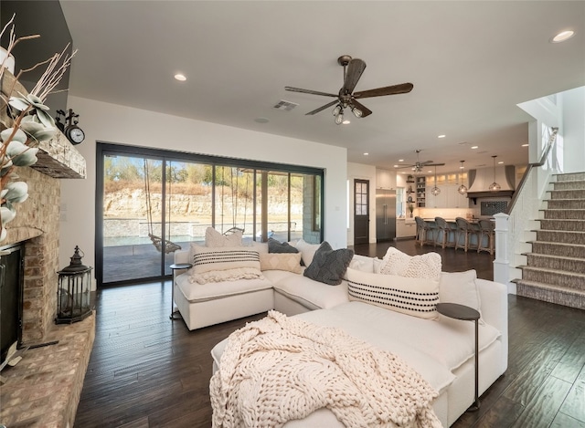102 Canyon Turn Trl, Austin, TX 78734 - living area featuring a ceiling fan, a fireplace with raised hearth, visible vents, dark wood-type flooring, and stairway