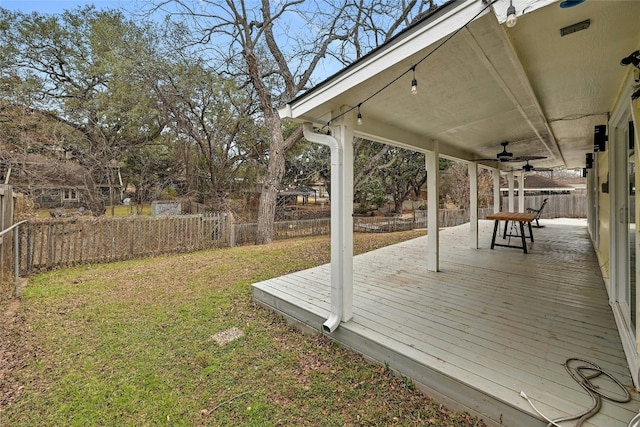 wooden deck featuring ceiling fan and a yard