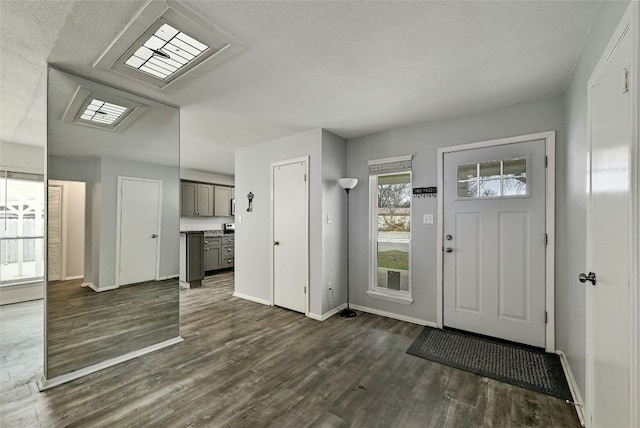 foyer entrance with a textured ceiling and dark hardwood / wood-style flooring