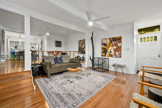 living room with hardwood / wood-style flooring, ceiling fan, and beam ceiling