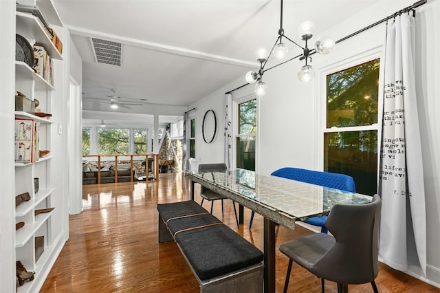 dining room with hardwood / wood-style flooring and ceiling fan with notable chandelier