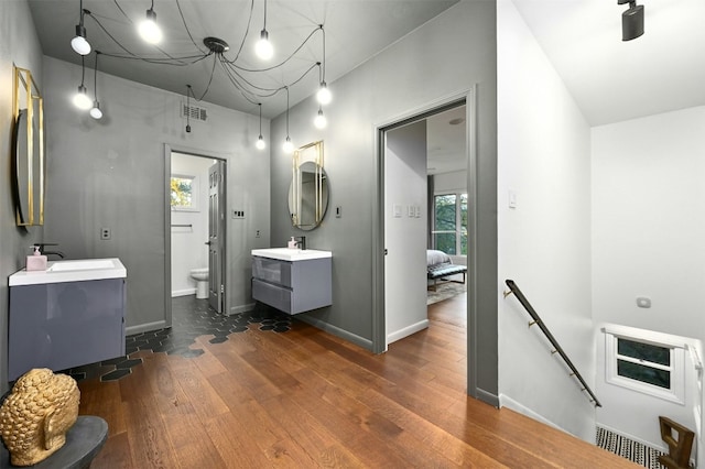 bathroom featuring wood-type flooring, vanity, and toilet