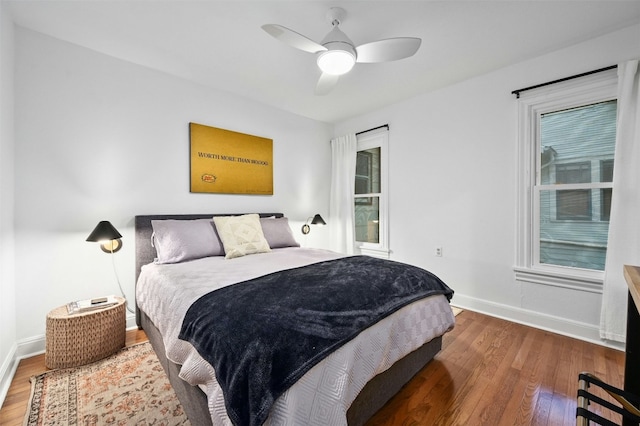 bedroom with ceiling fan, dark hardwood / wood-style floors, and multiple windows