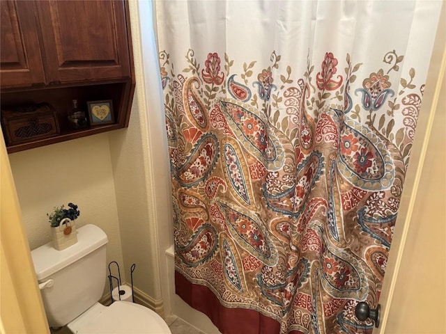 bathroom featuring a shower with curtain and toilet