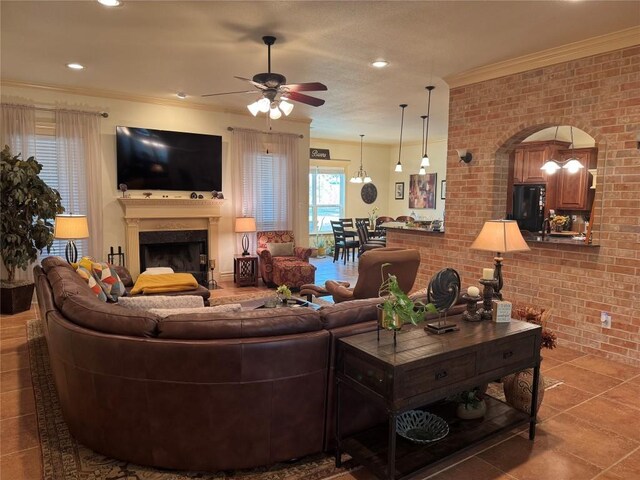 living room featuring ornamental molding, brick wall, and ceiling fan