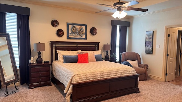 carpeted bedroom featuring crown molding and ceiling fan