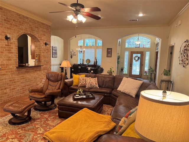 living room with brick wall, crown molding, and plenty of natural light